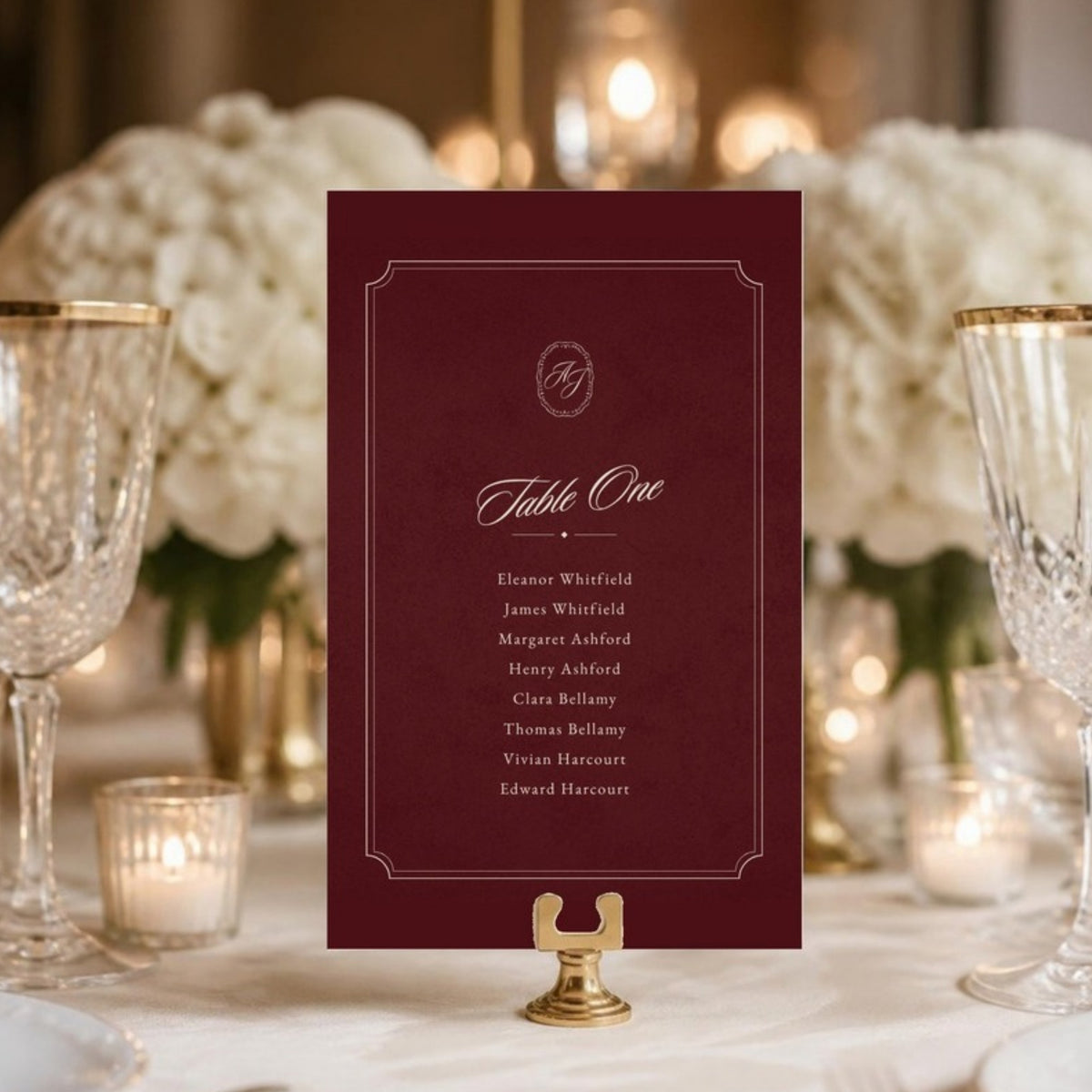 Table One card in a gold stand on a candlelit reception table