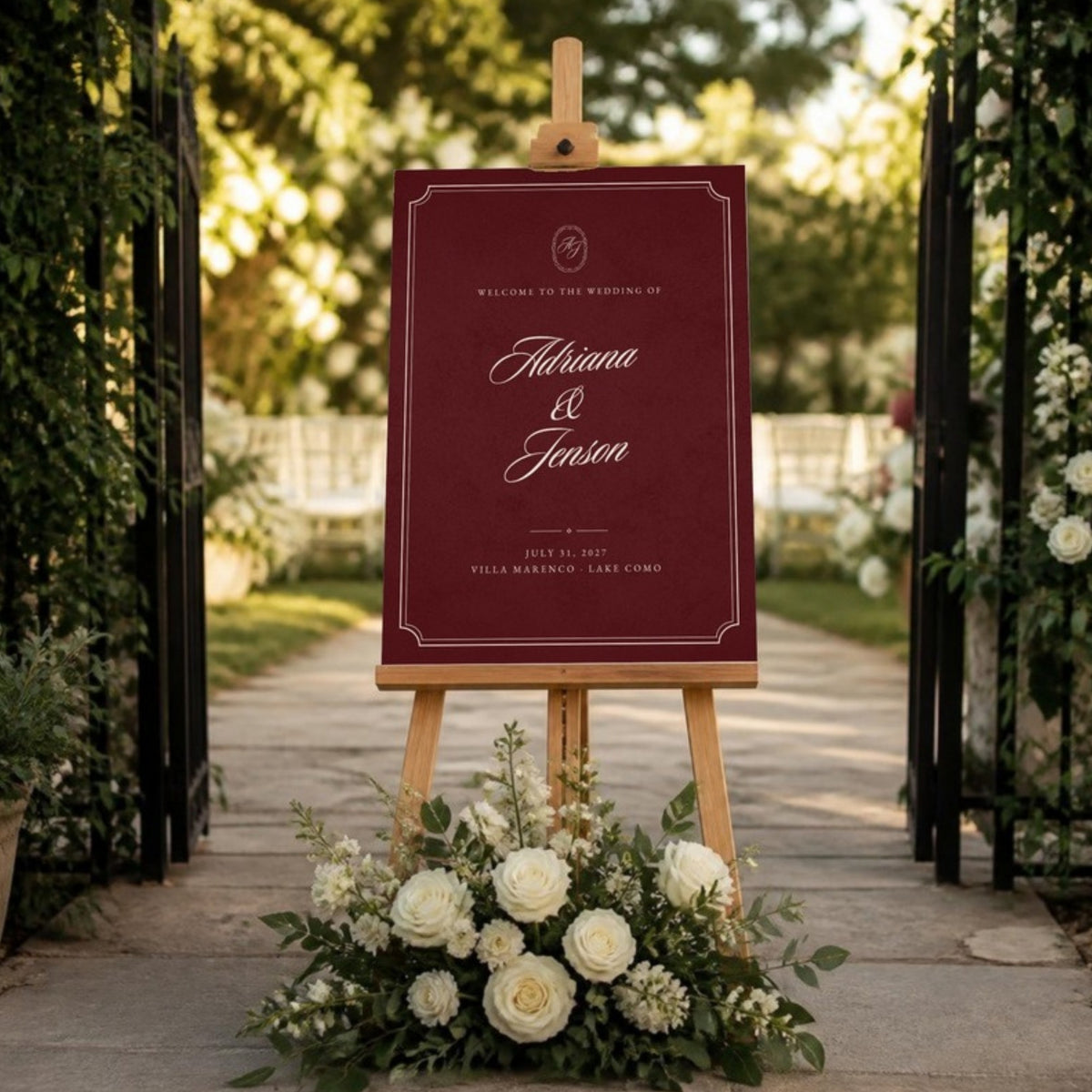 Burgundy welcome sign on an easel at a garden gate with white roses