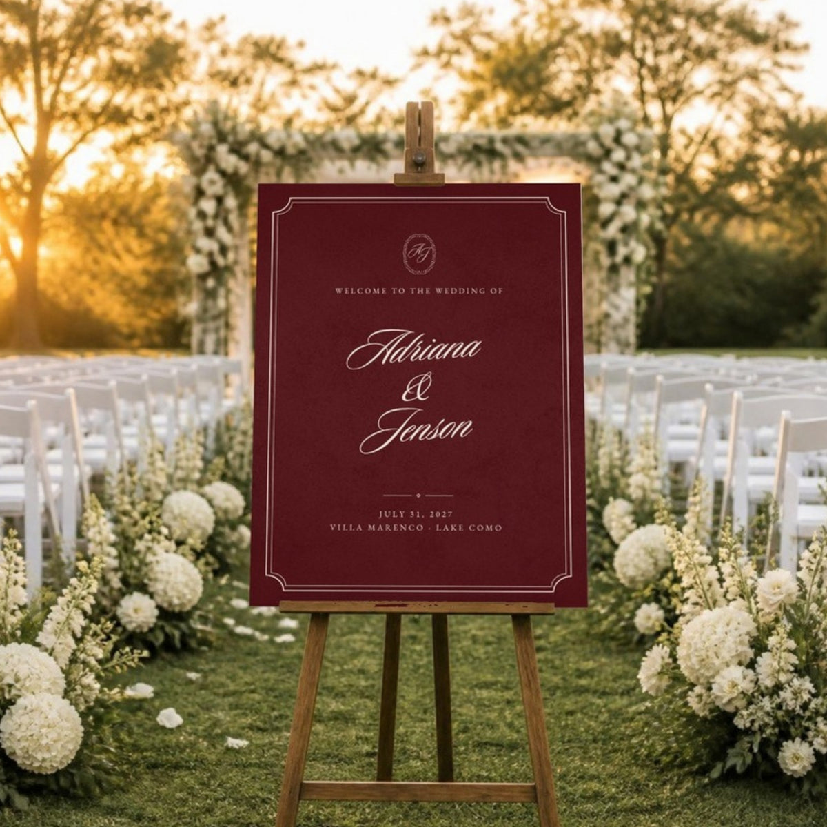 Burgundy welcome sign on an easel beside the ceremony aisle at sunset