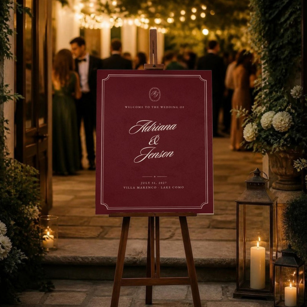 Burgundy welcome sign on an easel at an evening reception entrance with guests